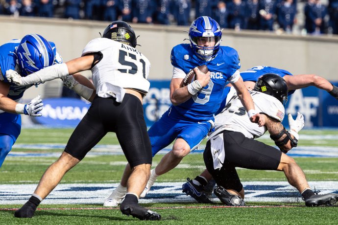 Air Force quarterback Liam Szarka runs with the ball between Army defenders during the first quarter.
