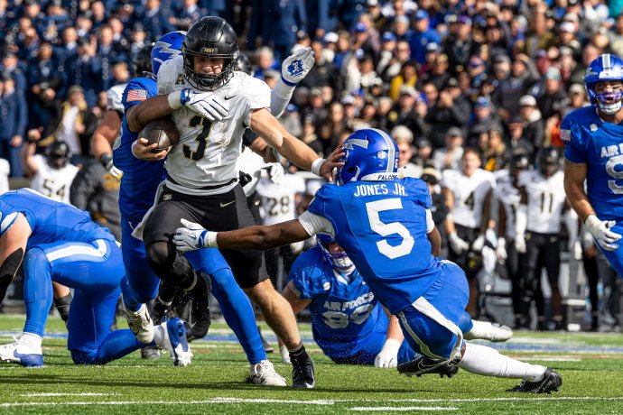 Army quarterback Cale Hellums stiff-arms Air Force defensive back Roger Jones Jr. while carrying the ball in the first quarter.