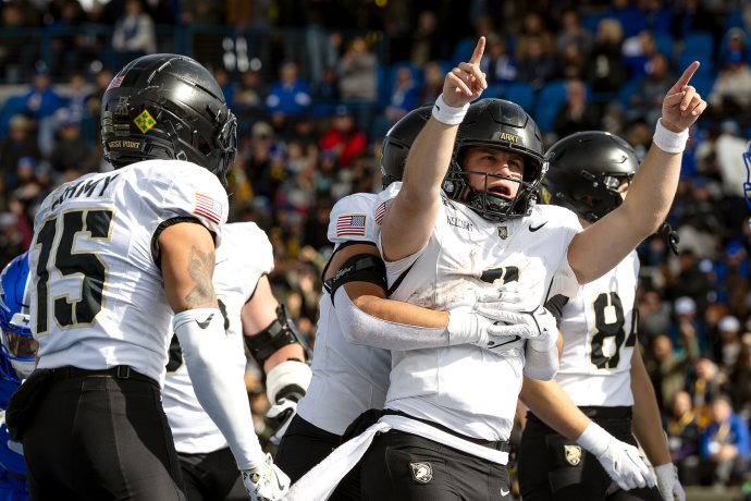 Army quarterback Cale Hellums raises both arms as teammates embrace him after his fourth-quarter touchdown against Air Force.