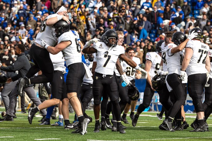 Army players celebrate together on the field after a 20-17 victory over Air Force at Falcon Stadium.