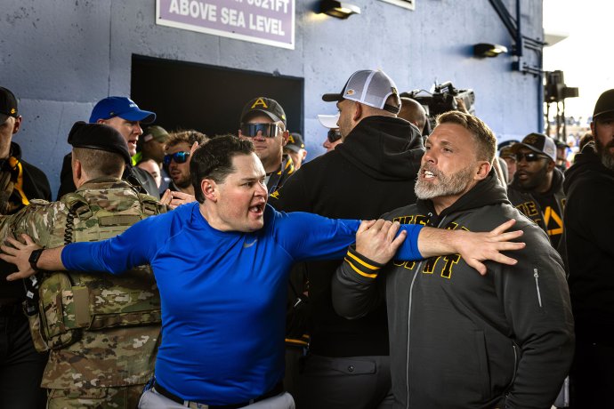 Army associate head coach Mike Viti shouts toward Air Force players as personnel separate the teams during a pregame altercation.