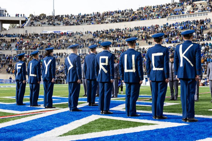 U.S. Air Force Academy cadets stand on the field with letters displayed across the backs of their uniforms during the pregame prisoner exchange tradition.