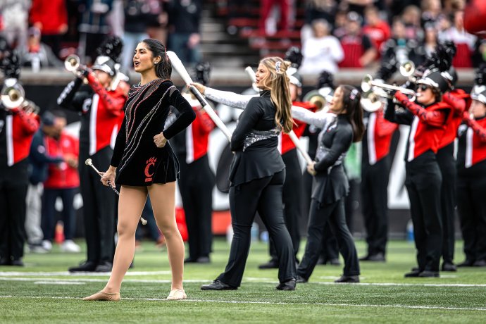 Cincinnati Bearcats twirler Lexi Peats sings the alma mater with the marching band before the game.