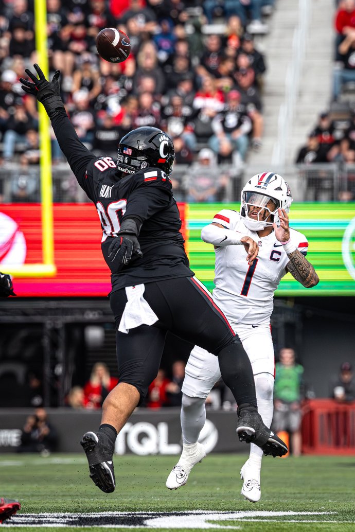Arizona quarterback Noah Fifita (1) throws under pressure as a Cincinnati defender reaches to contest the pass.
