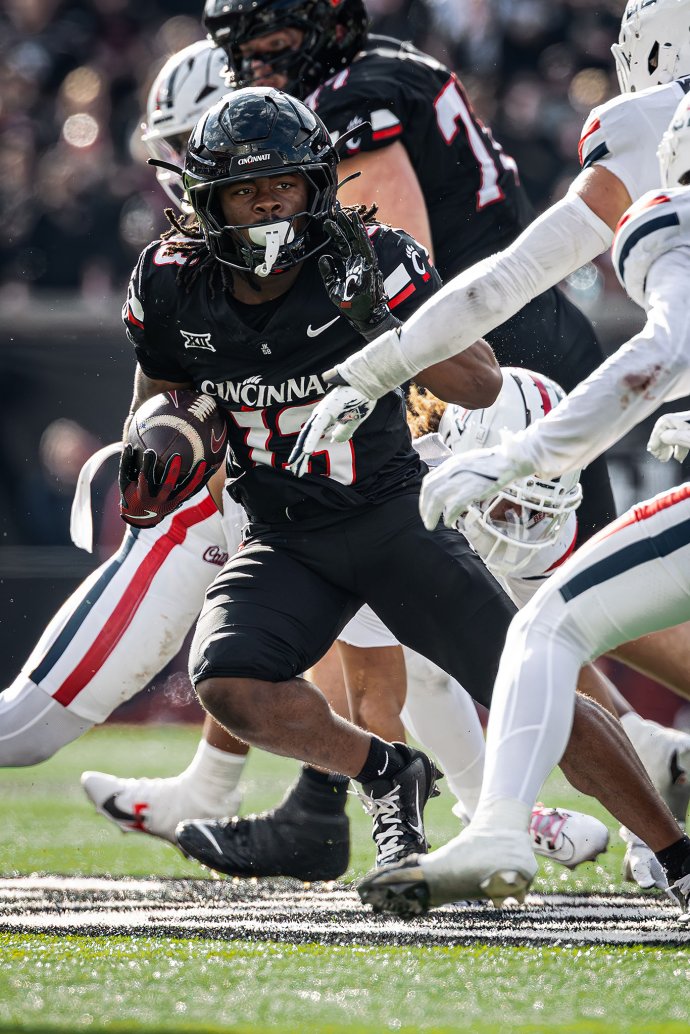 Cincinnati running back Zion Johnson (13) carries the ball through Arizona defenders.