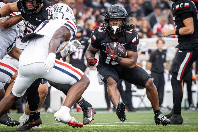 Cincinnati running back Zion Johnson (13) carries the ball through Arizona defenders.