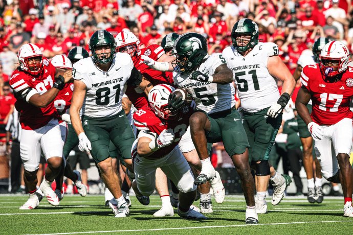 Michigan State running back Makhi Frazier (5) runs with the ball as a Nebraska defender attempts to tackle him.