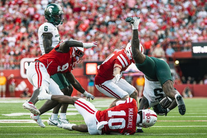 Michigan State running back Makhi Frazier (5) is tackled by multiple Nebraska defenders.