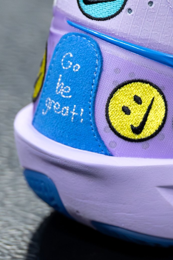 A close-up of Merritt Beason’s colorful shoe shows the handwritten message “Go be great!” on the side.