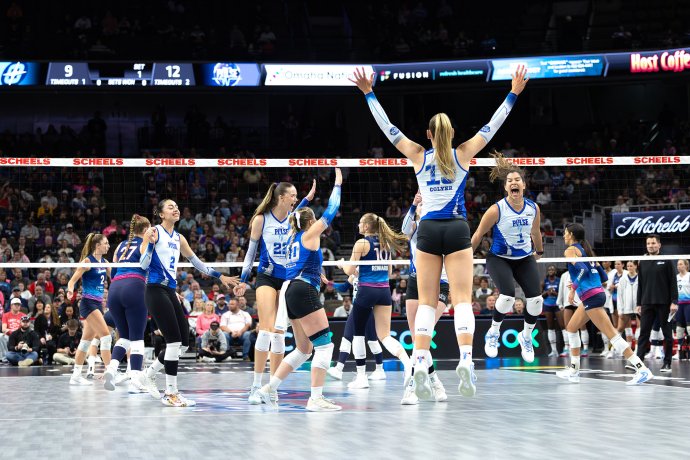 Dallas Pulse players celebrate a first-set point on the court against the Omaha Supernovas.