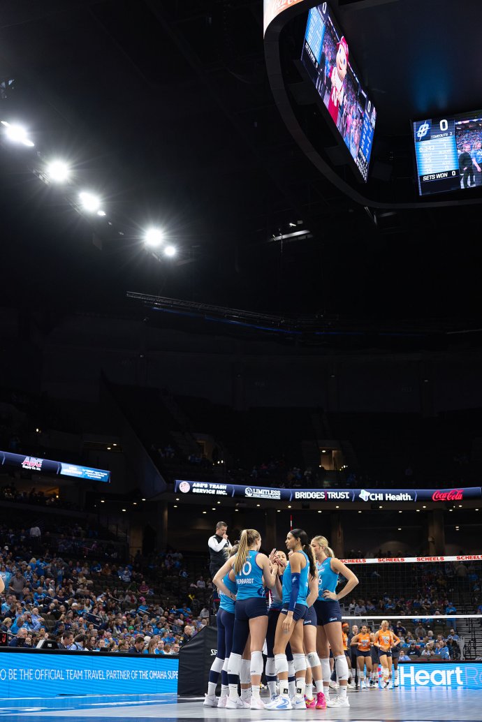 Omaha Supernovas players gather in a third-set huddle against the Indy Ignite as fans fill the stands at CHI Health Center Omaha.