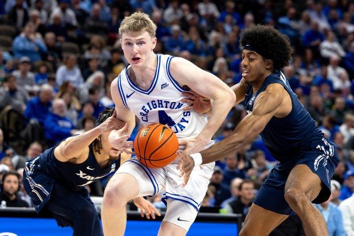 Creighton guard Josh Dix (4) drives with the basketball between two Xavier defenders.